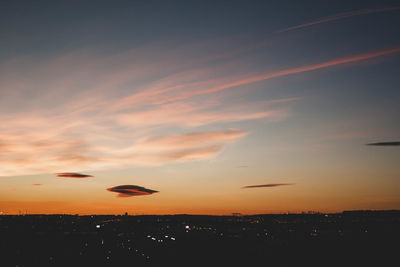 Silhouette of city against sky during sunset