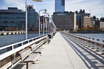 Bridge over river in city against sky