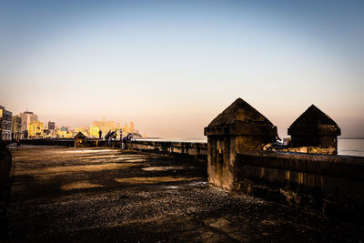 Buildings at waterfront against clear sky