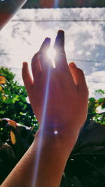 Close-up of hand against sky