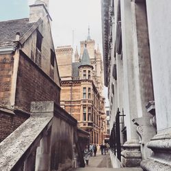 People walking on footpath amidst buildings