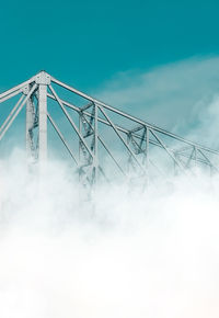 Low angle view of electricity pylon against sky