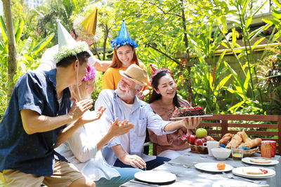 Rear view of a smiling young woman sitting on table