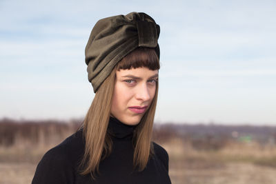 Portrait of young woman wearing headscarf against sky