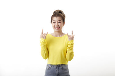 Portrait of smiling woman standing against white background