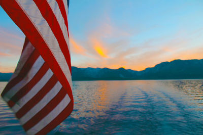 Cropped american flag against calm lake