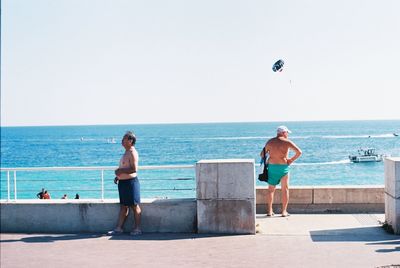 People on beach against clear sky