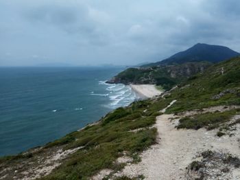Scenic view of sea and mountains against sky