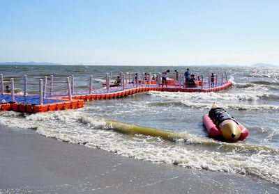 Rear view of woman swimming in sea against clear sky