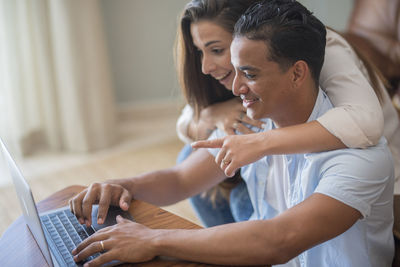 Side view of man using laptop at home