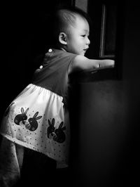 Cute boy looking away while standing at home