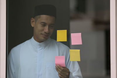 Portrait of young man holding box