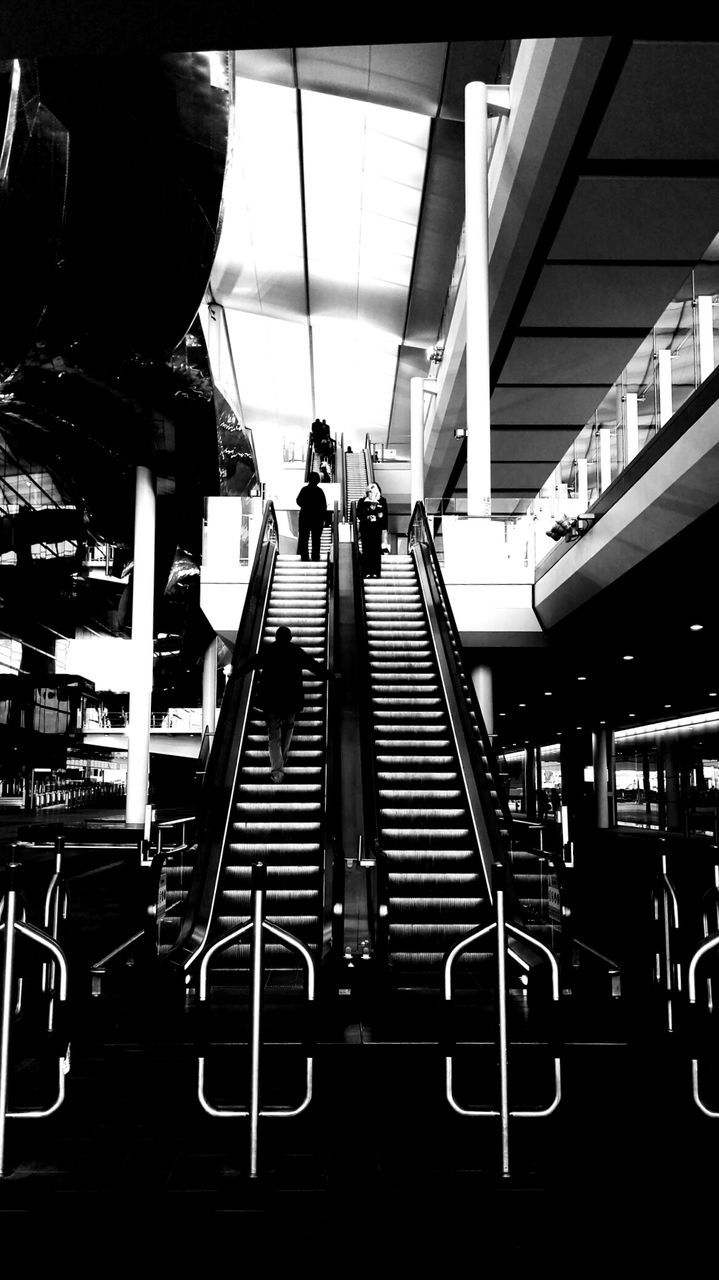 indoors, men, chair, built structure, in a row, architecture, person, lifestyles, modern, large group of people, railing, leisure activity, restaurant, repetition, table, day, arrangement, low angle view, order