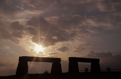 Low angle view of silhouette built structure against sky