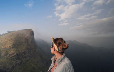 Woman standing on mountain against sky