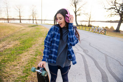 Portrait of a smiling young woman holding camera