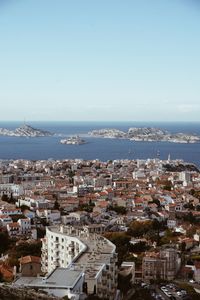 High angle view of townscape by sea against clear sky