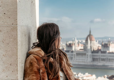 Sider view of young woman in front of cityscape of budapest, hungary