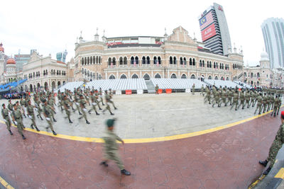 Group of people on street against buildings in city