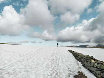 Man standing between clouds and snow, scenic view on corno del renon, south tyrol, italy in winter