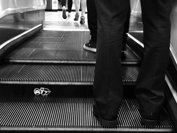 Low section of people standing on escalator