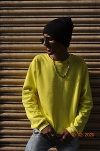 Man wearing sunglasses standing against shutter