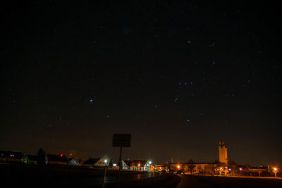 Low angle view of illuminated city against sky at night