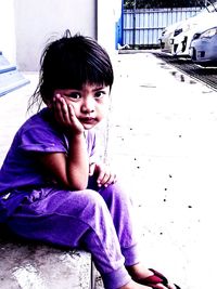 Portrait of cute girl sitting outdoors