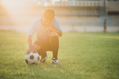 Man playing soccer ball on grass