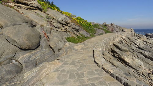 Scenic view of rocks and sea against clear sky