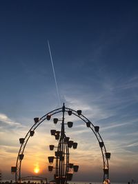 Low angle view of silhouette cranes against sky during sunset