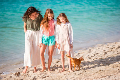 Mother with daughters standing on beach