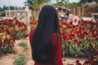 Rear view of woman standing against plants