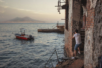 Rear view of man on sea against sky