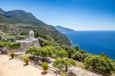 Scenic view of sea and mountains against blue sky