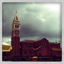 Low angle view of clock tower against cloudy sky