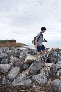 Full length of man standing on cliff against sky