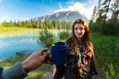 Portrait of smiling woman drinking coffee in mountains