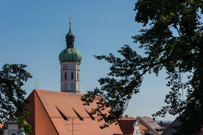Low angle view of trees and building against sky