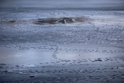 Scenic view of wet beach during winter