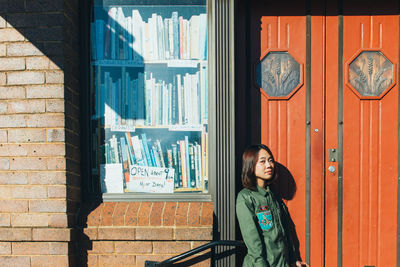 Portrait of woman standing against closed door