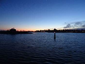 Silhouette bridge over river against sky during sunset