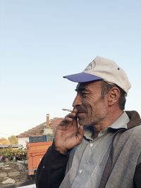 Portrait of man looking away against clear sky