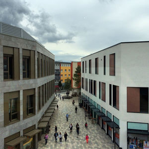 Buildings in city against cloudy sky