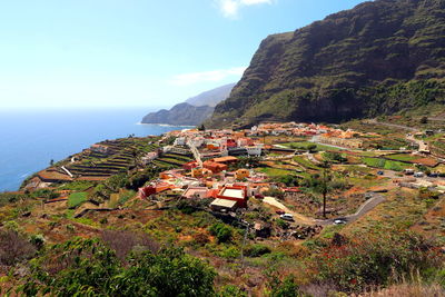 High angle view of houses by sea against sky