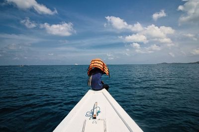 Rear view of man on sea against sky