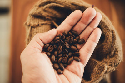 Close-up of hand holding coffee beans