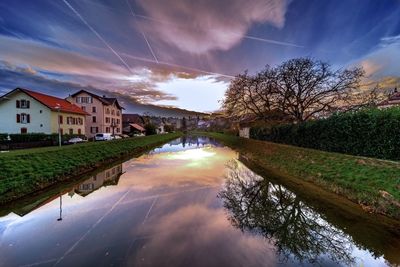 Reflection of houses in water against sky