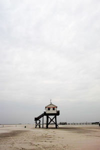 Lifeguard hut on beach against sky