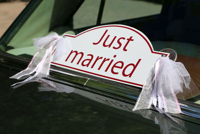 Close-up of information sign just married in car window 